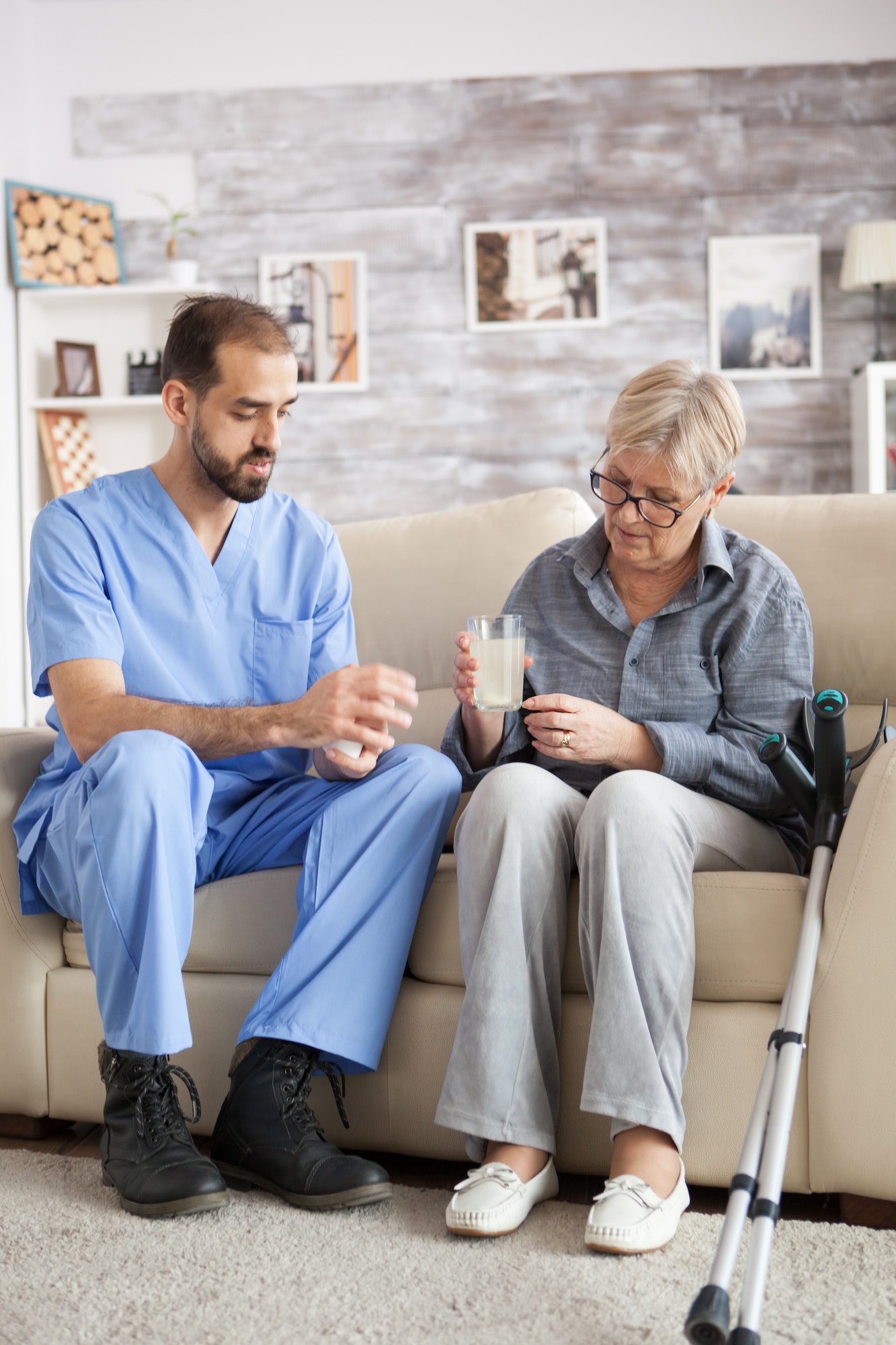 Male nurse sitting on couch with senior woman